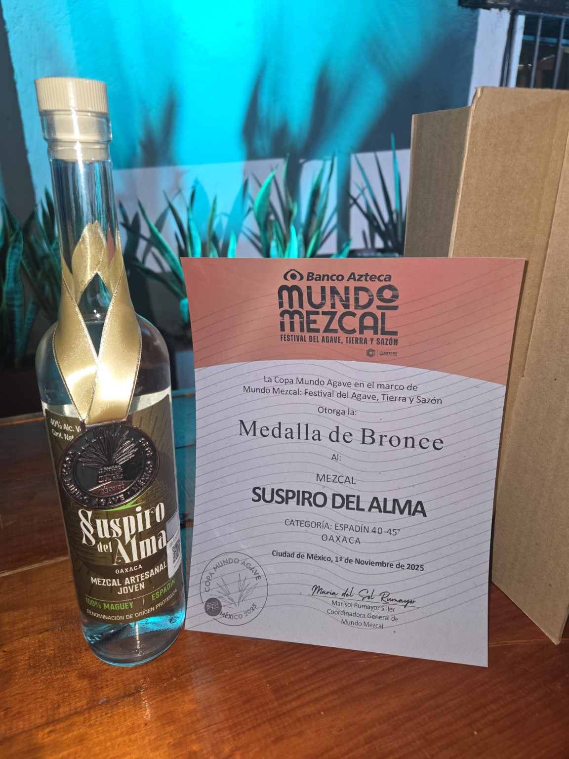 Botella de Suspiro del Alma con medalla de bronce junto al diploma de Copa Mundo Agave 2025